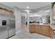 Open kitchen featuring tiled flooring, wood cabinets, and stainless steel refrigerator at 2709 Rue Montpellier Ave, Henderson, NV 89044