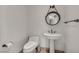Bathroom with pedestal sink, toilet, and decorative mirror at 2777 Paradise Rd # 301, Las Vegas, NV 89109