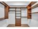 Walk-in closet with wood shelving and hanging racks and light-colored walls and flooring at 2777 Paradise Rd # 301, Las Vegas, NV 89109