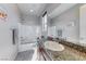 A well-lit bathroom featuring granite counters, a sink, and a shower over tub with white tile at 28 Vista Outlook St, Henderson, NV 89011