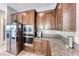 Close-up of modern kitchen appliances and granite countertops with wood cabinets at 28 Vista Outlook St, Henderson, NV 89011