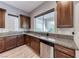 Kitchen with granite countertops, wood cabinets, stainless steel dishwasher, and view to backyard at 28 Vista Outlook St, Henderson, NV 89011