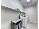 A functional laundry room featuring modern washer and dryer, a folding table, and ample shelving at 28 Vista Outlook St, Henderson, NV 89011