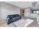 Cozy living room with a gray sofa, area rug, and light wood-look flooring at 28 Vista Outlook St, Henderson, NV 89011