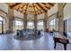 Bright lounge area with stone pillars, wood ceiling, herringbone floors, and golf course views at 28 Vista Outlook St, Henderson, NV 89011