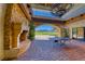 Covered outdoor patio featuring stone fireplace, table tennis, and views of the golf course and mountains at 28 Vista Outlook St, Henderson, NV 89011