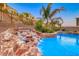 Close up of a unique rock waterfall feature cascading into the sparkling pool and spa at 28 Vista Outlook St, Henderson, NV 89011