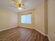 This bedroom features wood floors, a ceiling fan, and a bright window that fills the space with natural light at 3038 Tarpon Dr # 103, Las Vegas, NV 89120