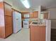 Functional kitchen featuring wood cabinets, white appliances, and a convenient layout for efficient meal preparation and storage at 3038 Tarpon Dr # 103, Las Vegas, NV 89120