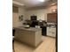 Kitchen featuring white cabinetry, black appliances, a center island with granite countertops and tile flooring at 312 Sierra Breeze Ave, North Las Vegas, NV 89031