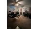 Cozy living room with a plush black sofa, patterned rug, and staircase under a warm ceiling fan at 312 Sierra Breeze Ave, North Las Vegas, NV 89031