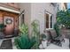Inviting front entrance with a charming garden, seating area and a decorative wreath on the front door at 3185 Mura Del Prato Ave, Henderson, NV 89044