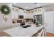 Bright kitchen with white cabinets, stainless steel appliances and large center island with marble countertop at 3185 Mura Del Prato Ave, Henderson, NV 89044