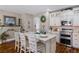 Elegant kitchen featuring white cabinetry, an island with seating, and a decorative fireplace mantel at 3185 Mura Del Prato Ave, Henderson, NV 89044