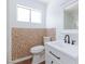 Bathroom with mosaic-style backsplash, white toilet, sink, modern black hardware and new flooring at 3821 1/2 Daisy St # 26, Las Vegas, NV 89119