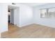 Bright bedroom featuring wood-look floors, a window with blinds, white walls, and closet space at 3821 1/2 Daisy St # 26, Las Vegas, NV 89119