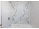 Close up of shower and tub with white marble patterned tile surround and chrome shower head at 3821 1/2 Daisy St # 26, Las Vegas, NV 89119