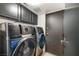 A laundry room featuring modern front loading washer and dryer units and black cabinets at 3911 Kamden Way, Las Vegas, NV 89119