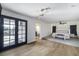 Spacious bedroom with French doors, modern lighting, and a cozy elevated sleeping area at 3911 Kamden Way, Las Vegas, NV 89119