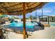 Resort-style pool area with a thatched tiki hut and a waterfall feature for relaxation and entertainment at 3911 Kamden Way, Las Vegas, NV 89119