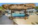 Resort-style pool area with a thatched tiki hut and a waterfall feature for relaxation and entertainment at 3911 Kamden Way, Las Vegas, NV 89119