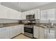 Bright kitchen with white cabinets, stainless steel appliances, and granite countertops at 4130 Lucas Ave, Las Vegas, NV 89120