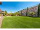 Expansive backyard featuring artificial turf, putting green, a decorative retaining wall, and ambient string lights at 47 Grand Masters Dr, Las Vegas, NV 89141