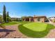A lovely backyard with a putting green, comfortable patio seating, and desert landscaping at 47 Grand Masters Dr, Las Vegas, NV 89141