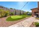 Charming backyard featuring a putting green, manicured landscaping, and a covered patio for outdoor enjoyment at 47 Grand Masters Dr, Las Vegas, NV 89141