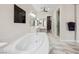 Bright bathroom featuring soaking tub, double vanity, glass enclosed shower and marble floors at 47 Grand Masters Dr, Las Vegas, NV 89141