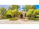 Beautiful clubhouse entrance features lush landscaping and decorative stone architecture at 47 Grand Masters Dr, Las Vegas, NV 89141