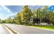 Scenic road leading to Southern Highlands Golf Club entrance sign amidst lush greenery and flowers at 47 Grand Masters Dr, Las Vegas, NV 89141