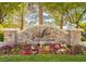 Landscaped entrance to Southern Highlands Spa featuring a stone sign and vibrant flowerbeds at 47 Grand Masters Dr, Las Vegas, NV 89141