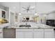 Kitchen island with a sink, stainless steel appliances, marble countertops, and views of the living area at 47 Grand Masters Dr, Las Vegas, NV 89141