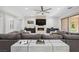 Cozy living room with a fireplace, large sofa, and access to the outdoor patio at 47 Grand Masters Dr, Las Vegas, NV 89141