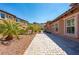 Paver walkway runs alongside the house, complemented by well-maintained desert landscaping and vibrant foliage at 47 Grand Masters Dr, Las Vegas, NV 89141