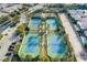 Aerial view of well-maintained tennis courts in a lush, landscaped setting, perfect for an active lifestyle at 47 Grand Masters Dr, Las Vegas, NV 89141
