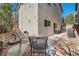 A shady patio area with metal chairs sits outside of a home with neutral stucco siding at 517 Primrose Hill Ave, Las Vegas, NV 89178