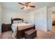 A cozy bedroom features a ceiling fan, a wood bed frame with decorative pillows, and double door closet at 517 Primrose Hill Ave, Las Vegas, NV 89178