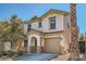 Inviting two-story home features a neutral color scheme, arched entryway, and attached garage, blending style and functionality at 517 Primrose Hill Ave, Las Vegas, NV 89178