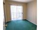 A sunlit bedroom featuring plush green carpet and a sliding glass door at 530 Sellers Pl, Henderson, NV 89011
