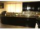 Spacious kitchen featuring dark wood cabinetry, granite countertops, and tile backsplash at 5381 Awbury Ave, Las Vegas, NV 89110