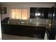 Kitchen boasts dark cabinetry, granite countertops, tiled backsplash, and stainless steel appliances at 5381 Awbury Ave, Las Vegas, NV 89110