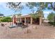 Private backyard with patio, rock landscaping, shade trees, and tranquil space for outdoor gatherings and relaxation at 5528 Apache Wells Way, Las Vegas, NV 89130