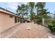 Large backyard features stone landscaping, a covered patio area, privacy landscaping, and comfortable outdoor living at 5528 Apache Wells Way, Las Vegas, NV 89130
