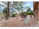 Charming backyard with patio seating, rock landscaping, mature trees, and serene setting for outdoor enjoyment at 5528 Apache Wells Way, Las Vegas, NV 89130