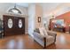 Elegant foyer with wood-look floors, double doors, and a comfortable chair at 5528 Apache Wells Way, Las Vegas, NV 89130
