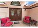Inviting front entry with double doors, decorative wreaths, and comfortable seating area at 5528 Apache Wells Way, Las Vegas, NV 89130