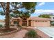 Beautiful home features a well-manicured front yard, mature trees, desert landscaping, and welcoming entry at 5528 Apache Wells Way, Las Vegas, NV 89130