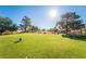 Picturesque golf course with manicured greens, mature trees, and a clear blue sky, perfect for a day of golfing at 5528 Apache Wells Way, Las Vegas, NV 89130